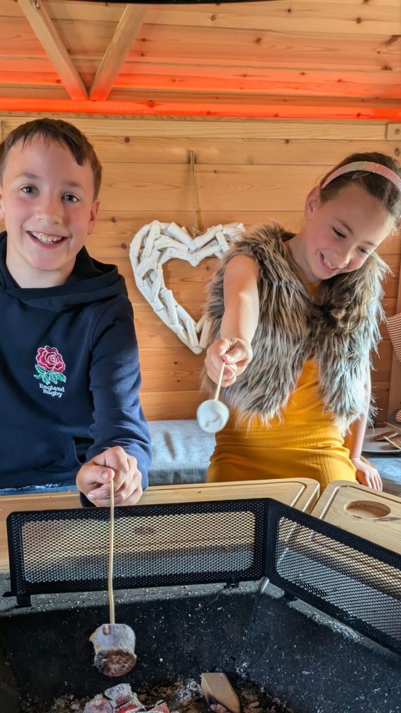 children toasting marshmallows in a bbq hut 