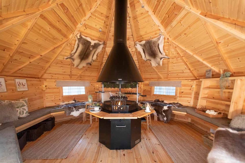 interior of a large barbecue cabin with reindeer skins decorating it
