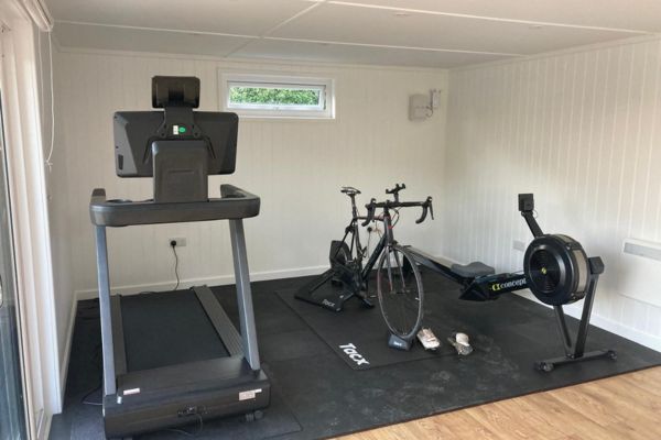 garden room with gym equipment inside it
